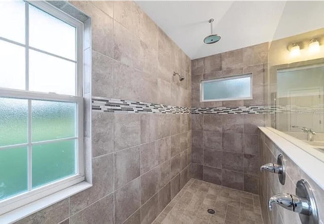 bathroom featuring a wealth of natural light and tiled shower