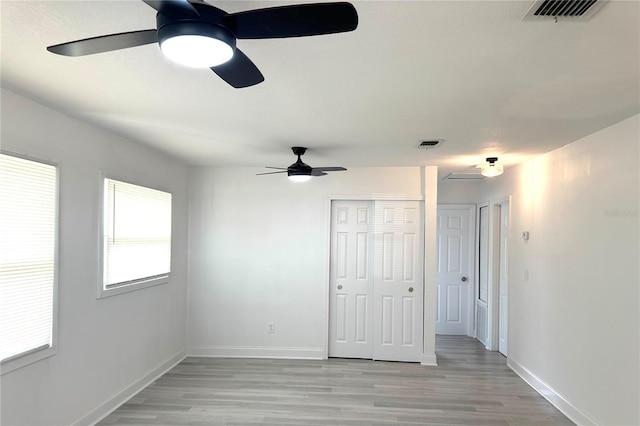 unfurnished bedroom with visible vents, a closet, and light wood finished floors