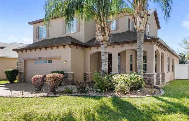 view of front facade featuring a front lawn, stucco siding, driveway, stone siding, and an attached garage