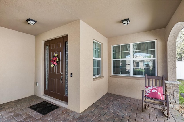 doorway to property featuring stucco siding