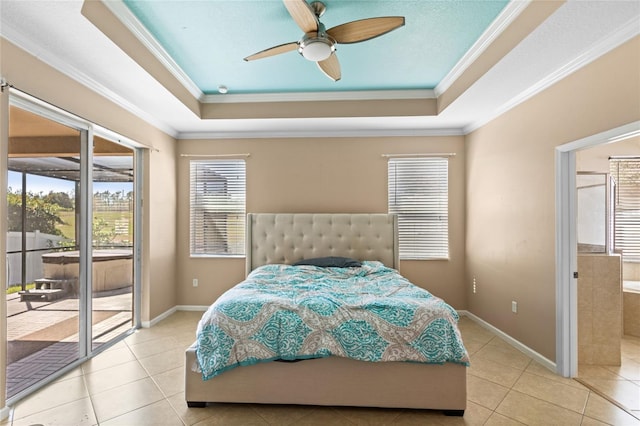 bedroom featuring ensuite bathroom, crown molding, a tray ceiling, and access to outside