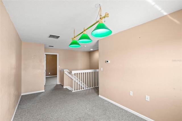 carpeted empty room with visible vents and baseboards