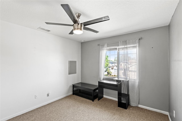 interior space featuring baseboards, visible vents, ceiling fan, a textured ceiling, and carpet flooring