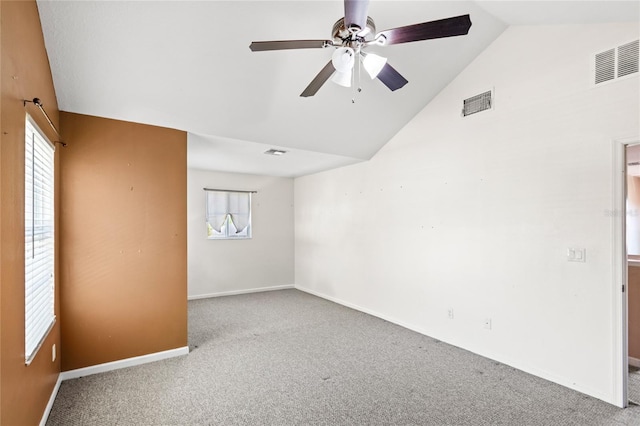 carpeted spare room with vaulted ceiling, visible vents, and ceiling fan