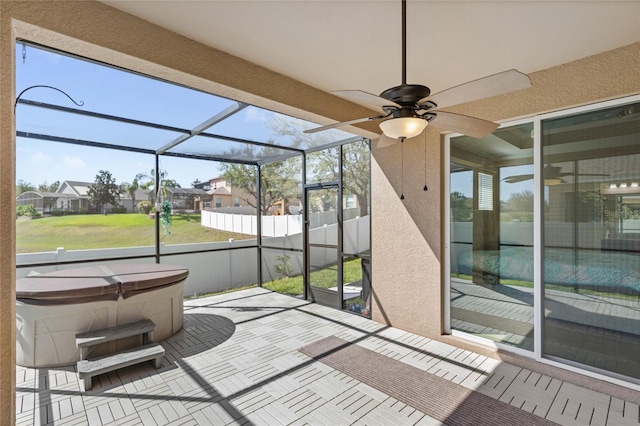 unfurnished sunroom with ceiling fan