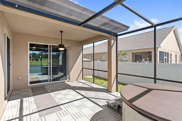 unfurnished sunroom featuring ceiling fan