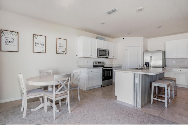 kitchen with visible vents, stainless steel appliances, white cabinets, light countertops, and light tile patterned floors