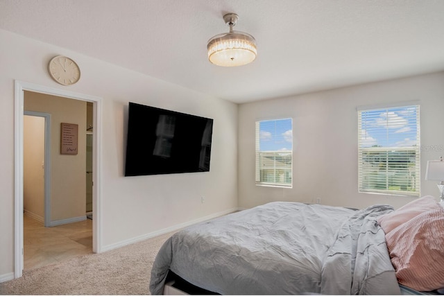 bedroom with light colored carpet and baseboards