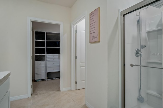 full bathroom with tile patterned flooring, a shower stall, vanity, and baseboards