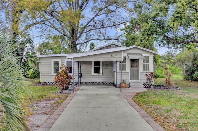 bungalow-style home featuring driveway, a front lawn, and entry steps