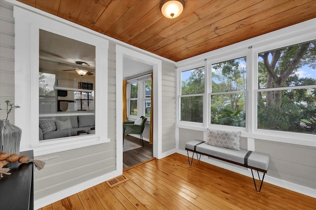 sunroom with wooden ceiling, visible vents, and ceiling fan