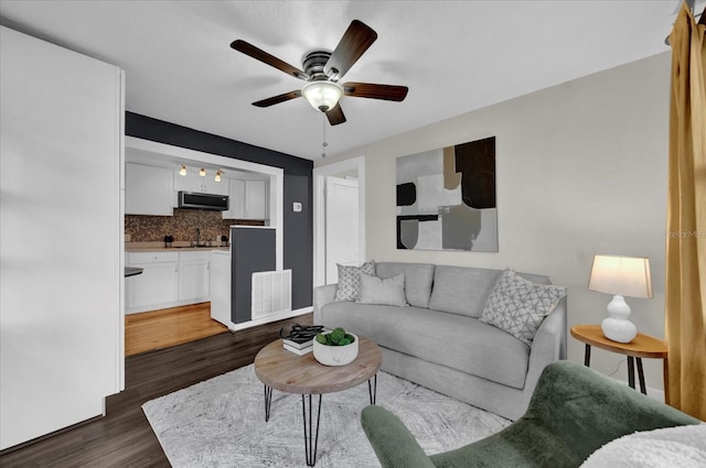 living room featuring dark wood finished floors, visible vents, and ceiling fan