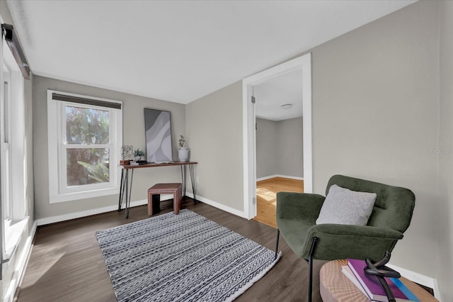 living area featuring baseboards and wood finished floors