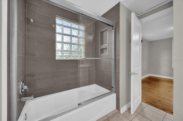 full bath featuring combined bath / shower with glass door, baseboards, and tile patterned flooring