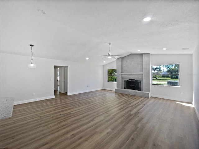 unfurnished living room featuring baseboards, lofted ceiling, a fireplace, dark wood-style floors, and a ceiling fan