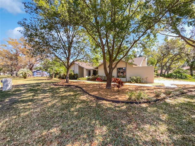 view of front of property featuring stucco siding and a front yard