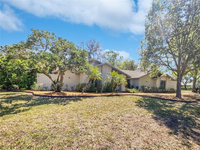 view of front of home featuring stucco siding and a front lawn