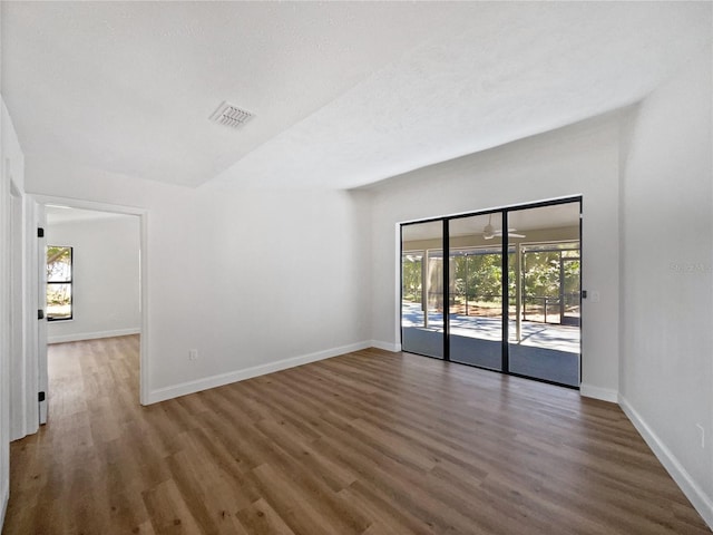 unfurnished room with visible vents, baseboards, and wood finished floors