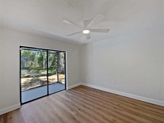 unfurnished room with a ceiling fan, wood finished floors, and baseboards