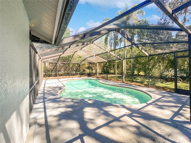 pool featuring glass enclosure and a patio