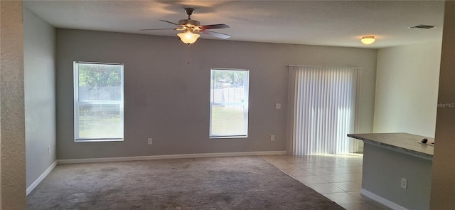 unfurnished room featuring visible vents, baseboards, light tile patterned flooring, and a ceiling fan