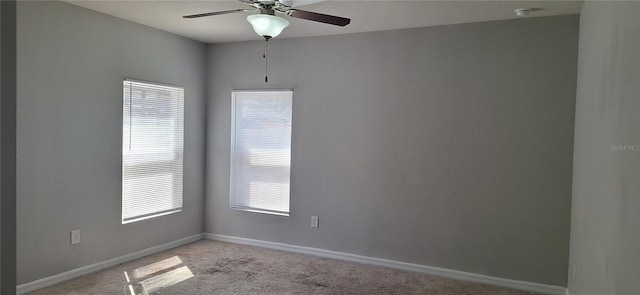 empty room with light colored carpet, baseboards, and ceiling fan