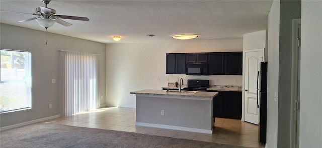 kitchen featuring ceiling fan, light countertops, dark cabinetry, black appliances, and a sink