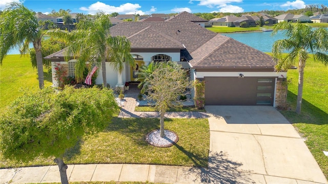 view of front of home with a garage, stucco siding, a front yard, and roof with shingles