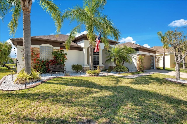 view of front of house featuring a front yard, concrete driveway, a garage, and stucco siding