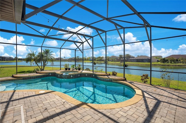 view of swimming pool featuring glass enclosure, a pool with connected hot tub, a patio, and a water view