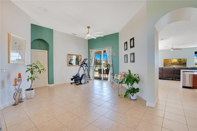 interior space with light tile patterned floors, baseboards, and arched walkways