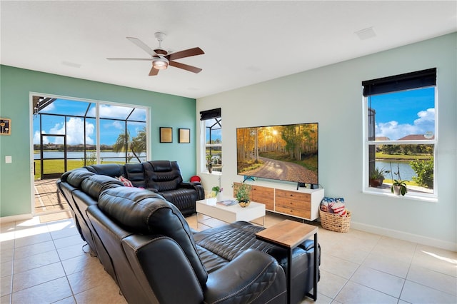 living room featuring light tile patterned floors, baseboards, and ceiling fan