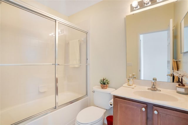 bathroom with toilet, vanity, and shower / bath combination with glass door