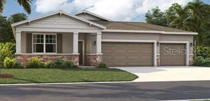 craftsman-style house with stone siding, a front yard, concrete driveway, and an attached garage