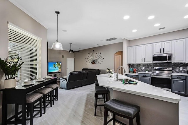 kitchen with visible vents, a sink, arched walkways, appliances with stainless steel finishes, and ceiling fan