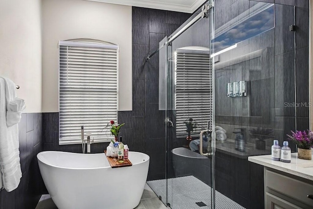 bathroom with a freestanding bath, a stall shower, tile walls, and vanity