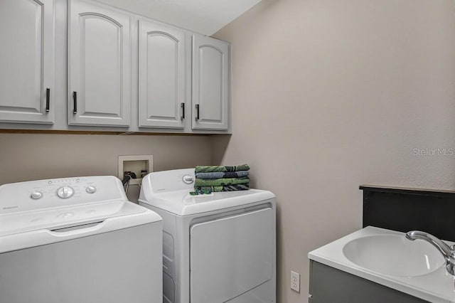 clothes washing area featuring cabinet space, separate washer and dryer, and a sink