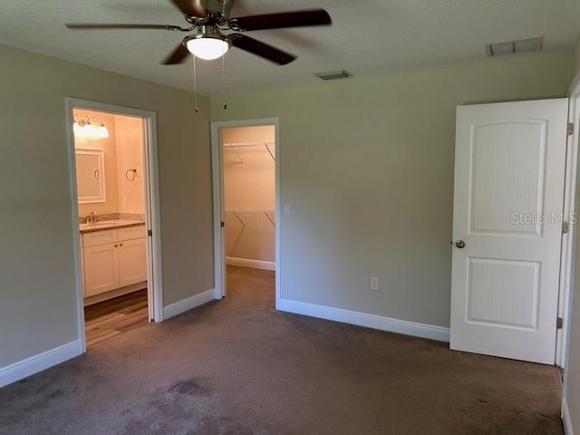 120 S Chandler Ave, Deland, FL 32724 - unfurnished bedroom featuring a walk in closet, carpet flooring, a closet, and baseboards