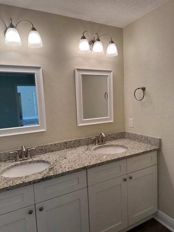 120 S Chandler Ave, Deland, FL 32724 - bathroom featuring double vanity and a textured ceiling