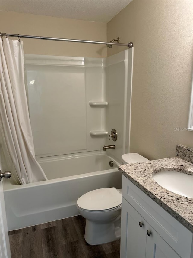 120 S Chandler Ave, Deland, FL 32724 - bathroom featuring wood finished floors, shower / tub combo with curtain, toilet, vanity, and a textured ceiling