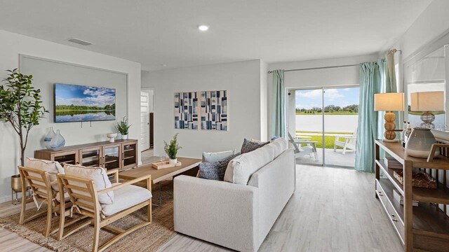 living room featuring light wood finished floors, visible vents, and recessed lighting