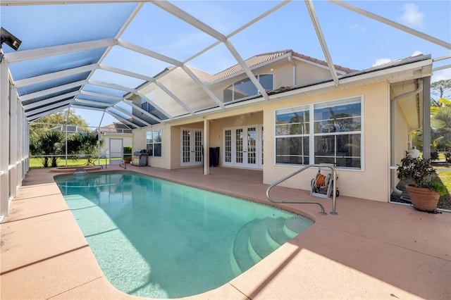 outdoor pool with a patio area, french doors, and a lanai