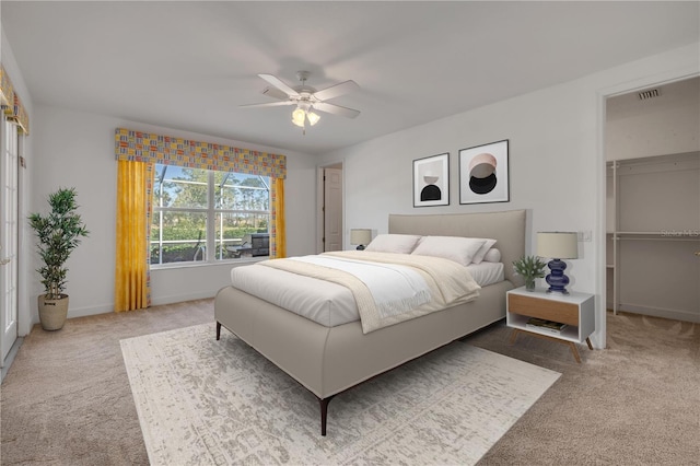 carpeted bedroom featuring visible vents, baseboards, ceiling fan, and a spacious closet