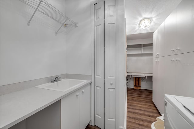 bathroom featuring toilet, a textured ceiling, wood finished floors, a closet, and vanity