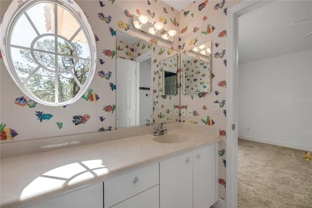 bathroom featuring wallpapered walls, vanity, and baseboards