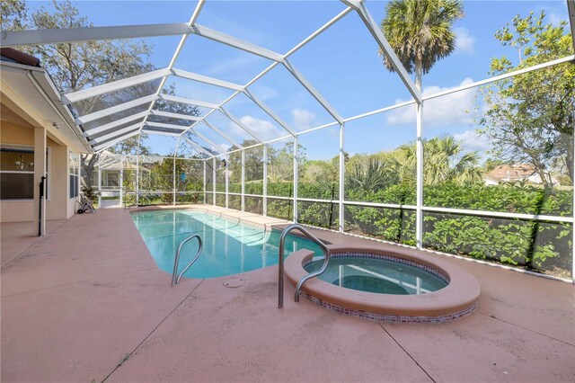 view of pool with a lanai, a pool with connected hot tub, and a patio