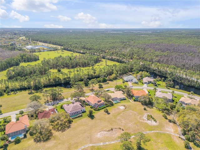 birds eye view of property with a water view and a wooded view