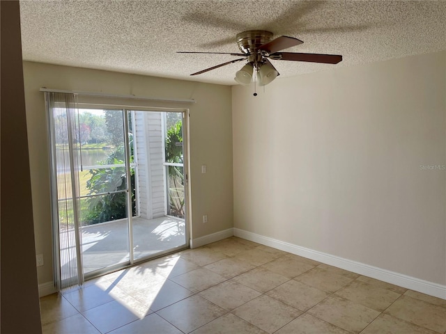 empty room featuring light tile patterned floors, baseboards, a textured ceiling, and ceiling fan