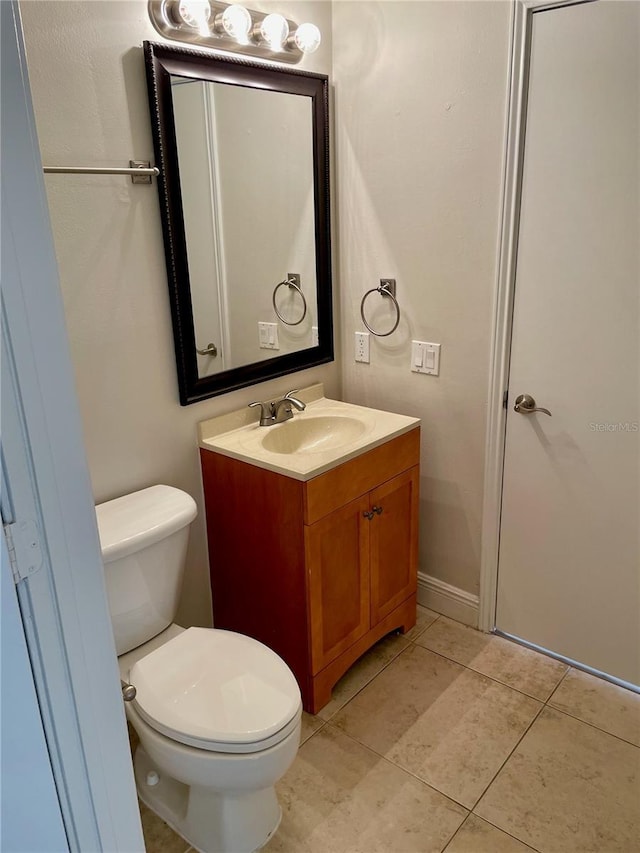 bathroom with vanity, tile patterned floors, toilet, and baseboards