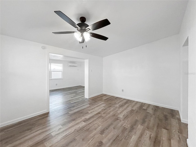 unfurnished room with baseboards, wood finished floors, a ceiling fan, and a wall mounted AC